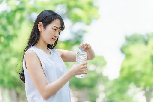 ペットボトルを開ける女性